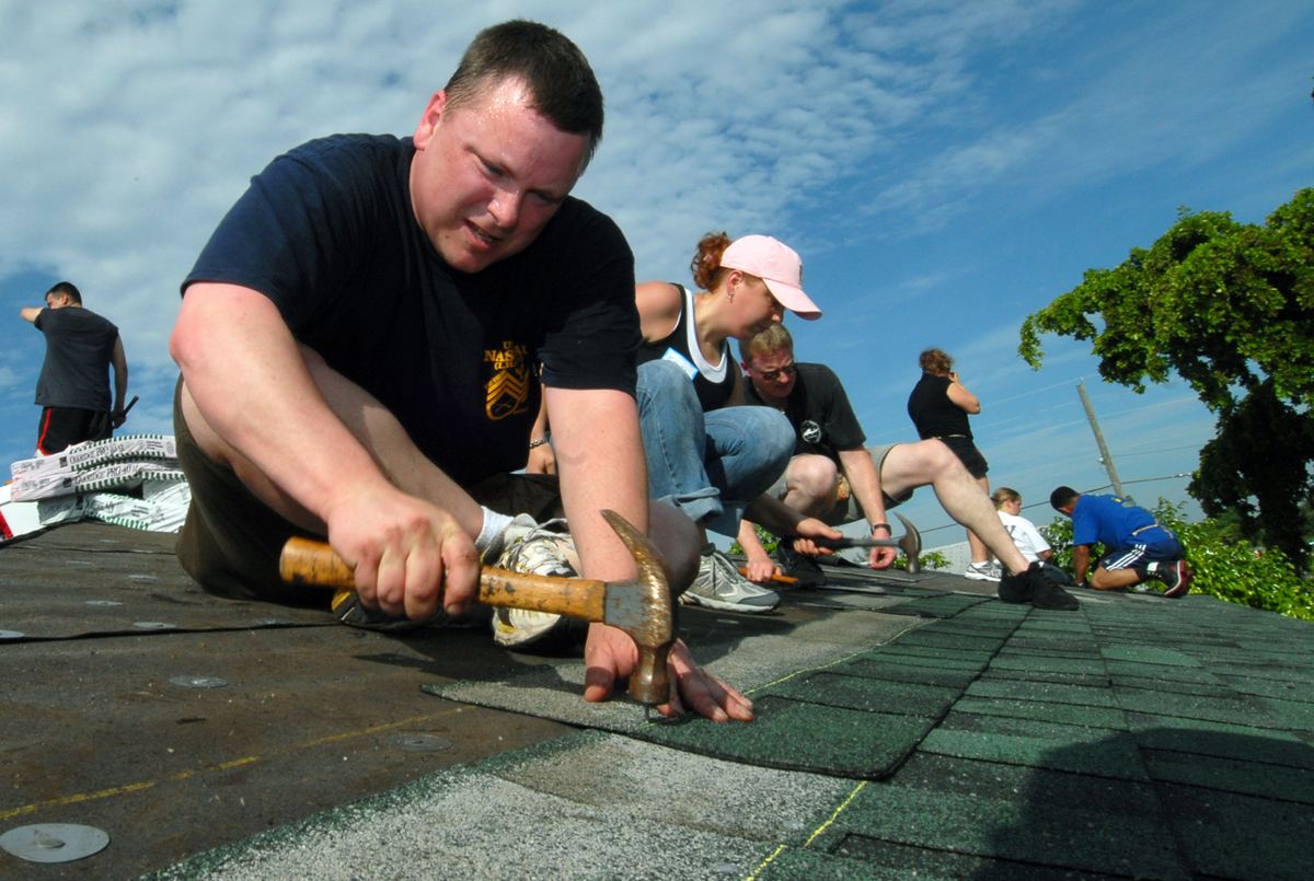 Roofer nailing new shingles into place on a residential roof
